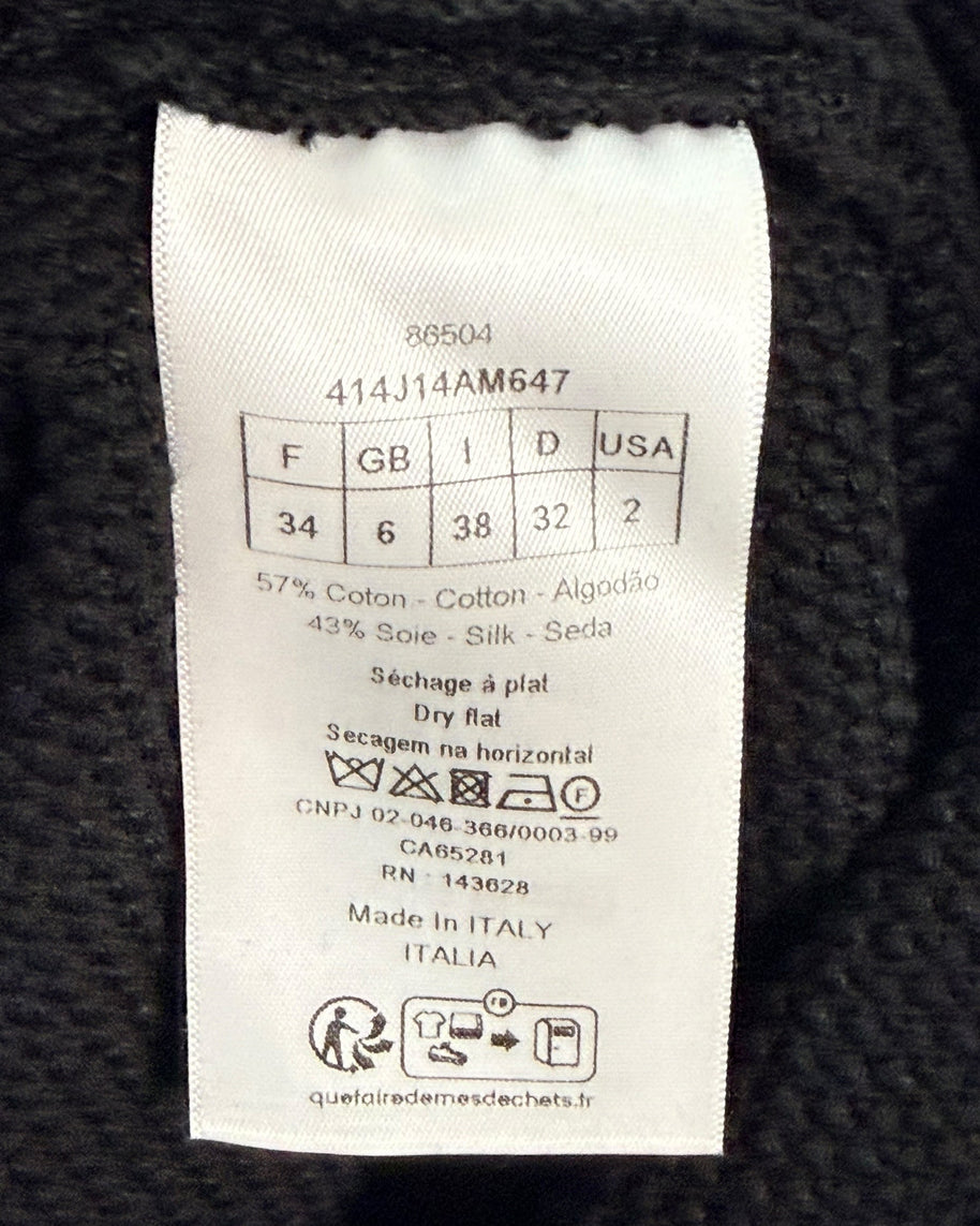 Close-up of Dior knit skirt care and size label showing cotton-silk blend, FR 34 sizing, and Made in Italy origin.
