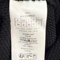 Close-up of Dior knit skirt care and size label showing cotton-silk blend, FR 34 sizing, and Made in Italy origin.
