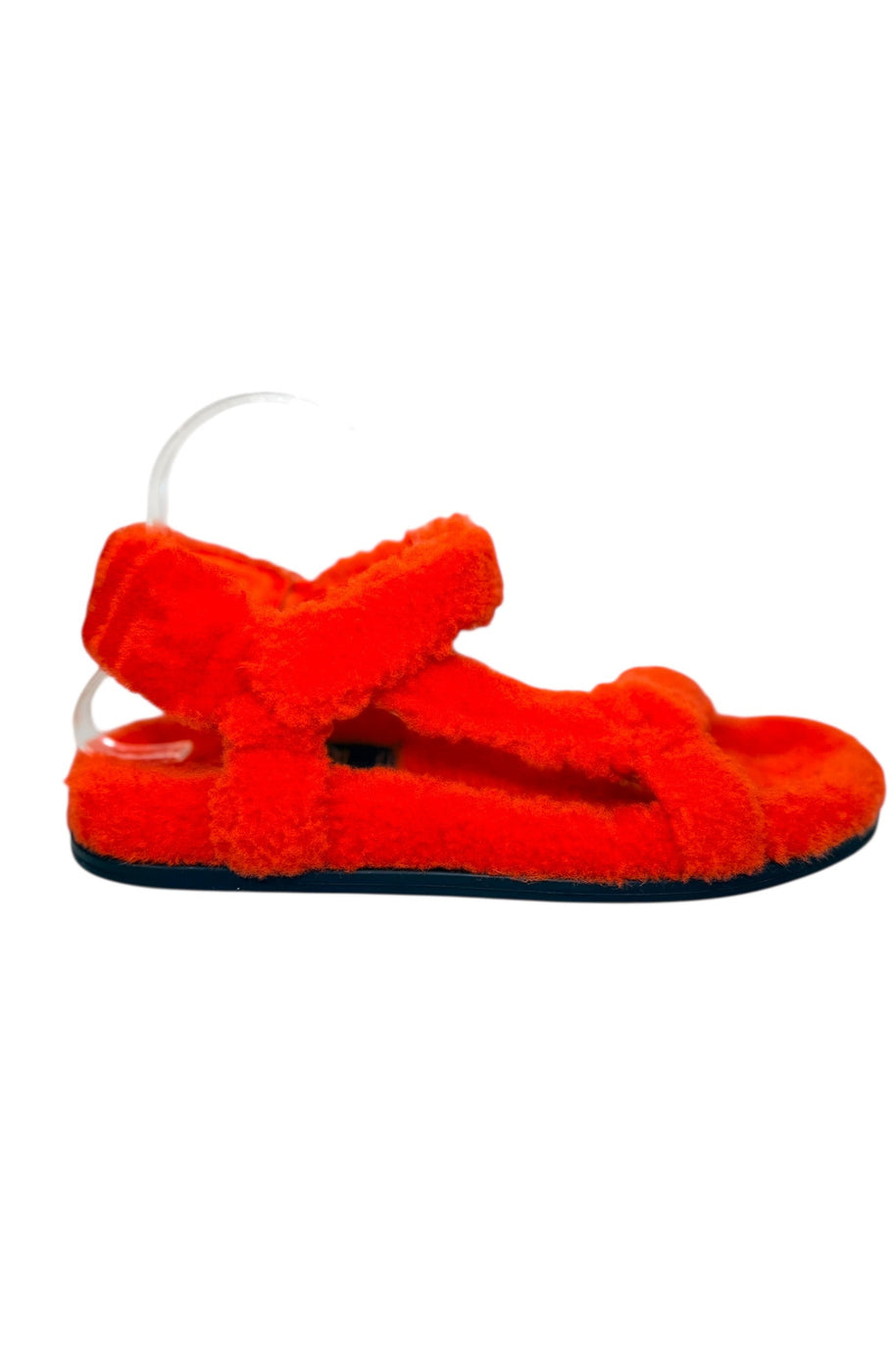 Left side profile of Fendi red shearling flat sandals showing plush shearling straps and flat rubber sole