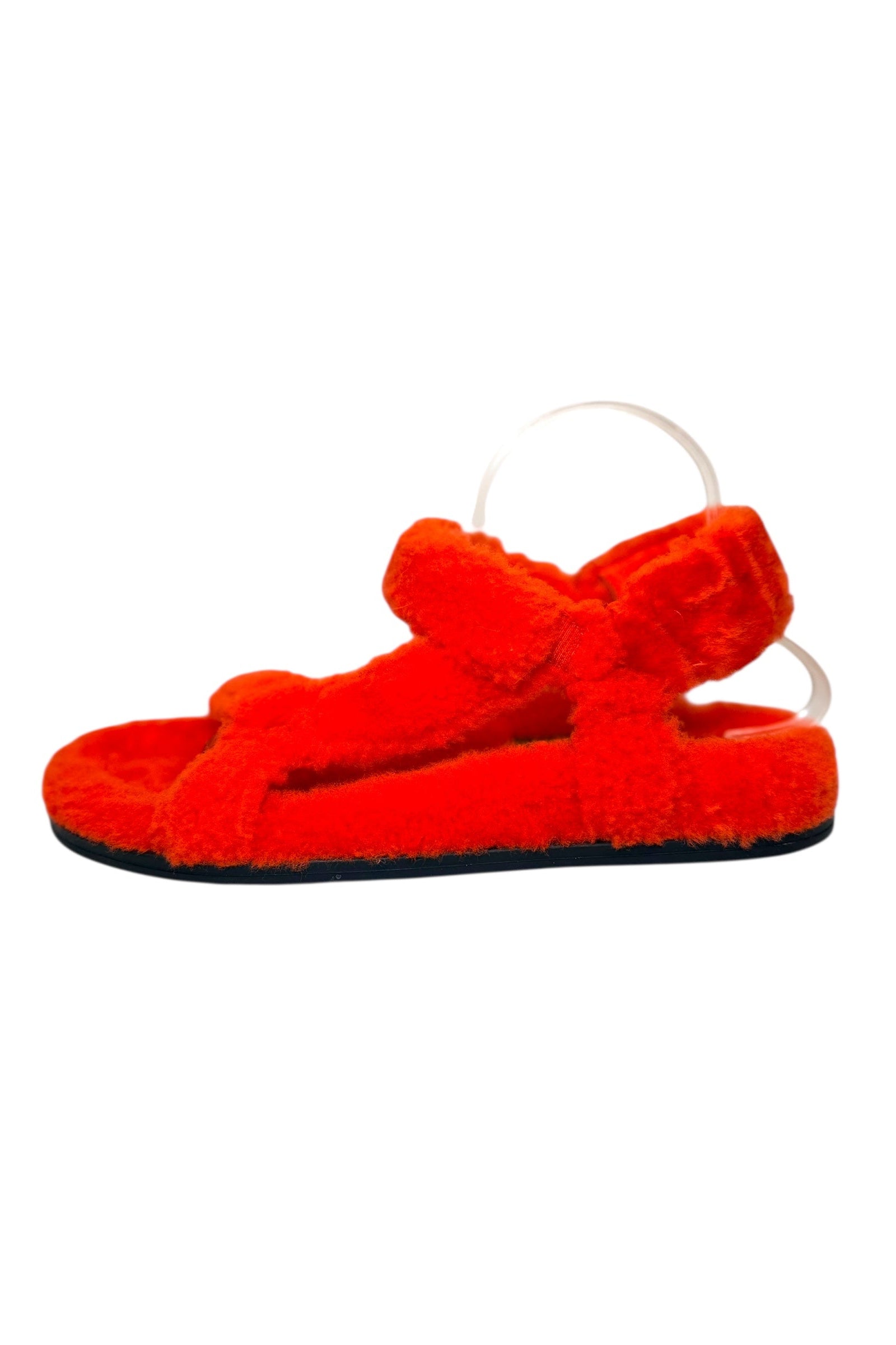 Side angled view of Fendi red shearling sandals highlighting crossover front straps and flat sole