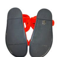 Bottom sole view of Fendi red shearling flat sandals with black rubber sole and Fendi branding
