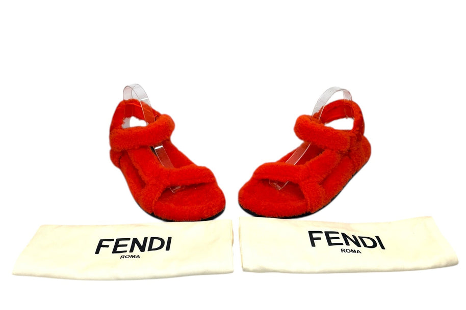Fendi red shearling flat sandals displayed with original Fendi Roma dust bags, luxury designer footwear