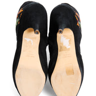 Pair of Giuseppe Zanotti black suede ankle boot shoes with bejeweled star embellishments view of soles with size '39' and 'made in italy' stamped into soles on a white background