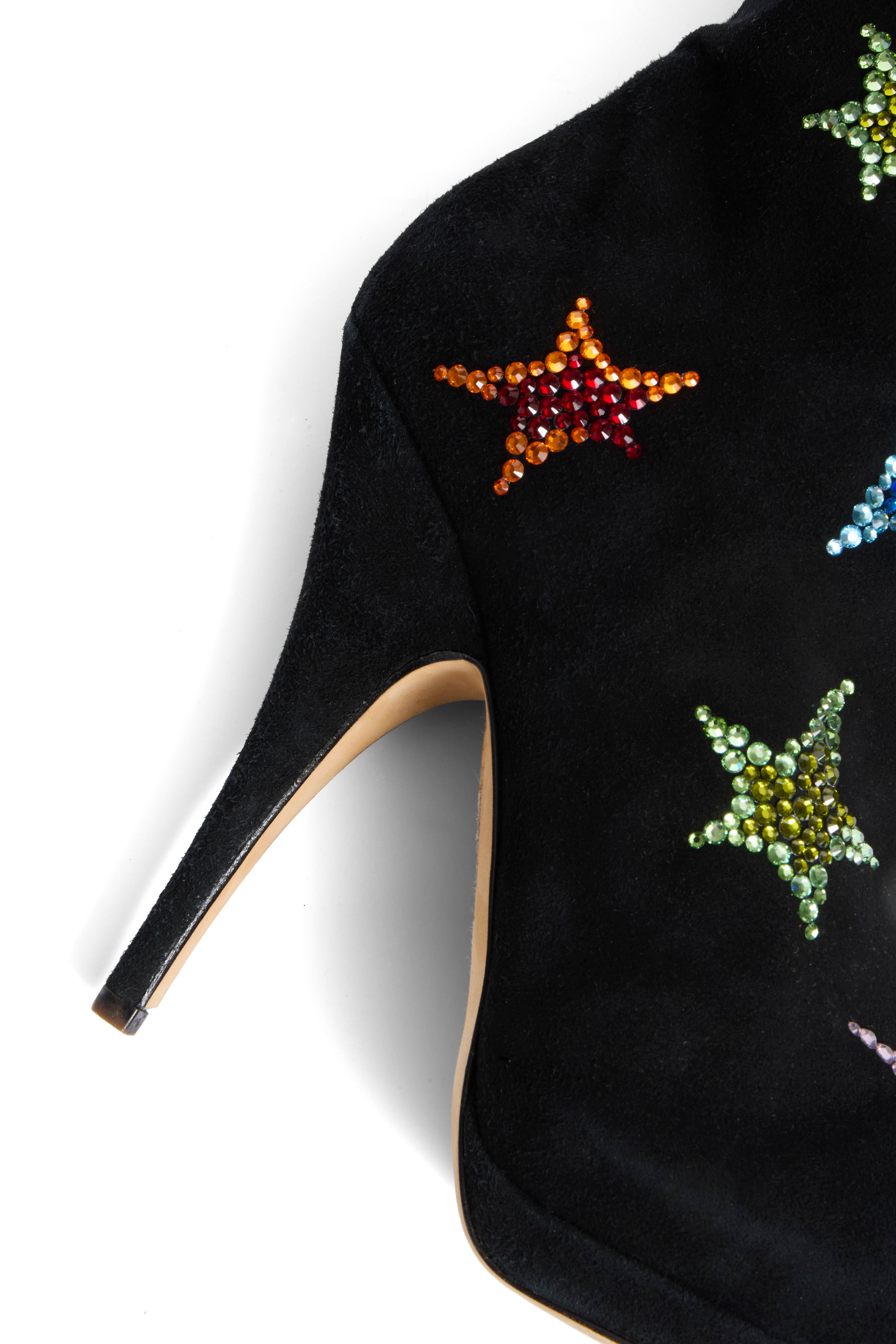 Giuseppe Zanotti Black suede high-heeled boot with colorful star embellishments close-up of right shoe heel on a white background
