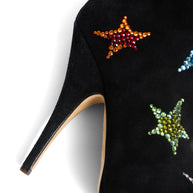 Giuseppe Zanotti Black suede high-heeled boot with colorful star embellishments close-up of right shoe heel on a white background