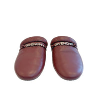 Pair of Givenchy burgundy leather slides on a white background