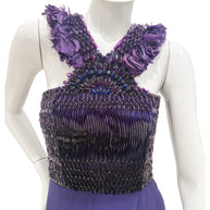 Close-up of Gucci gown bodice showing pleated satin, beadwork, and purple feather embellishments.