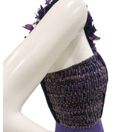 Close-up side image of Gucci gown highlighting textured beadwork and pleated satin on bodice.