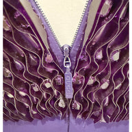 Close-up of Gucci-branded zipper surrounded by purple pleated satin and beaded embellishment on the back of the gown.
