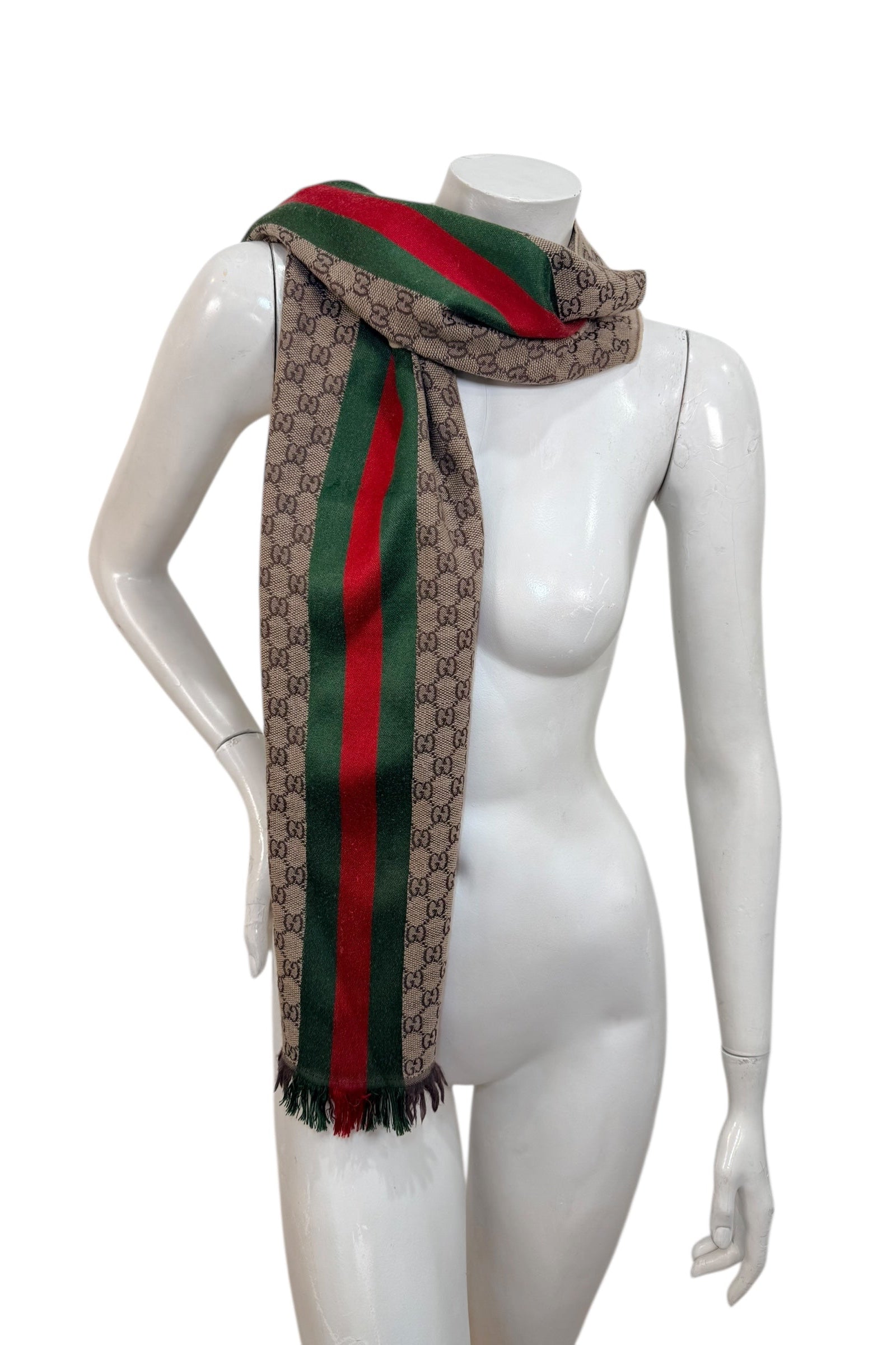 Gucci GG monogram web stripe scarf styled over shoulder on mannequin, luxury Italian accessory