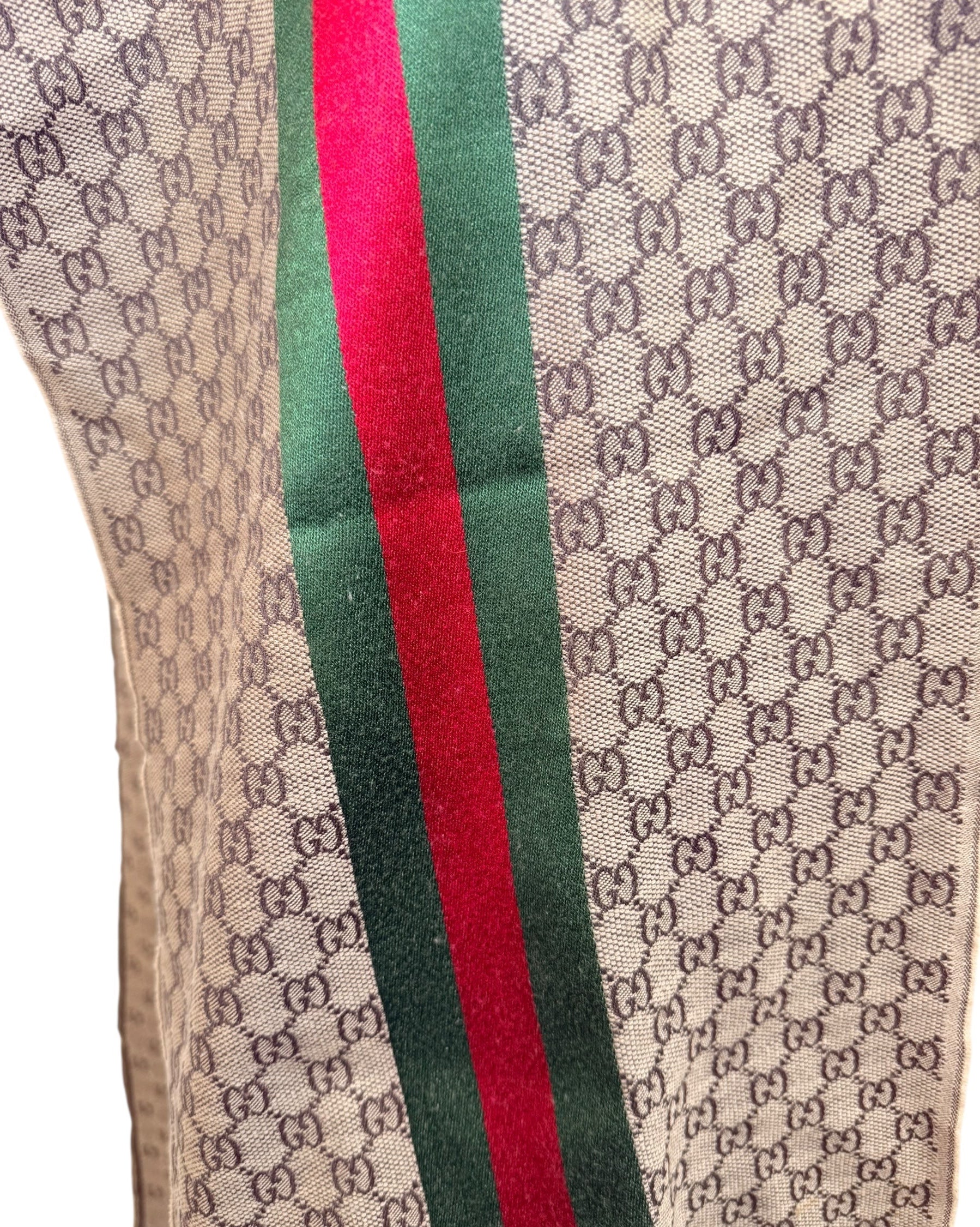 Macro view of Gucci GG monogram scarf fabric showing woven texture and web stripe