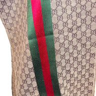 Macro view of Gucci GG monogram scarf fabric showing woven texture and web stripe