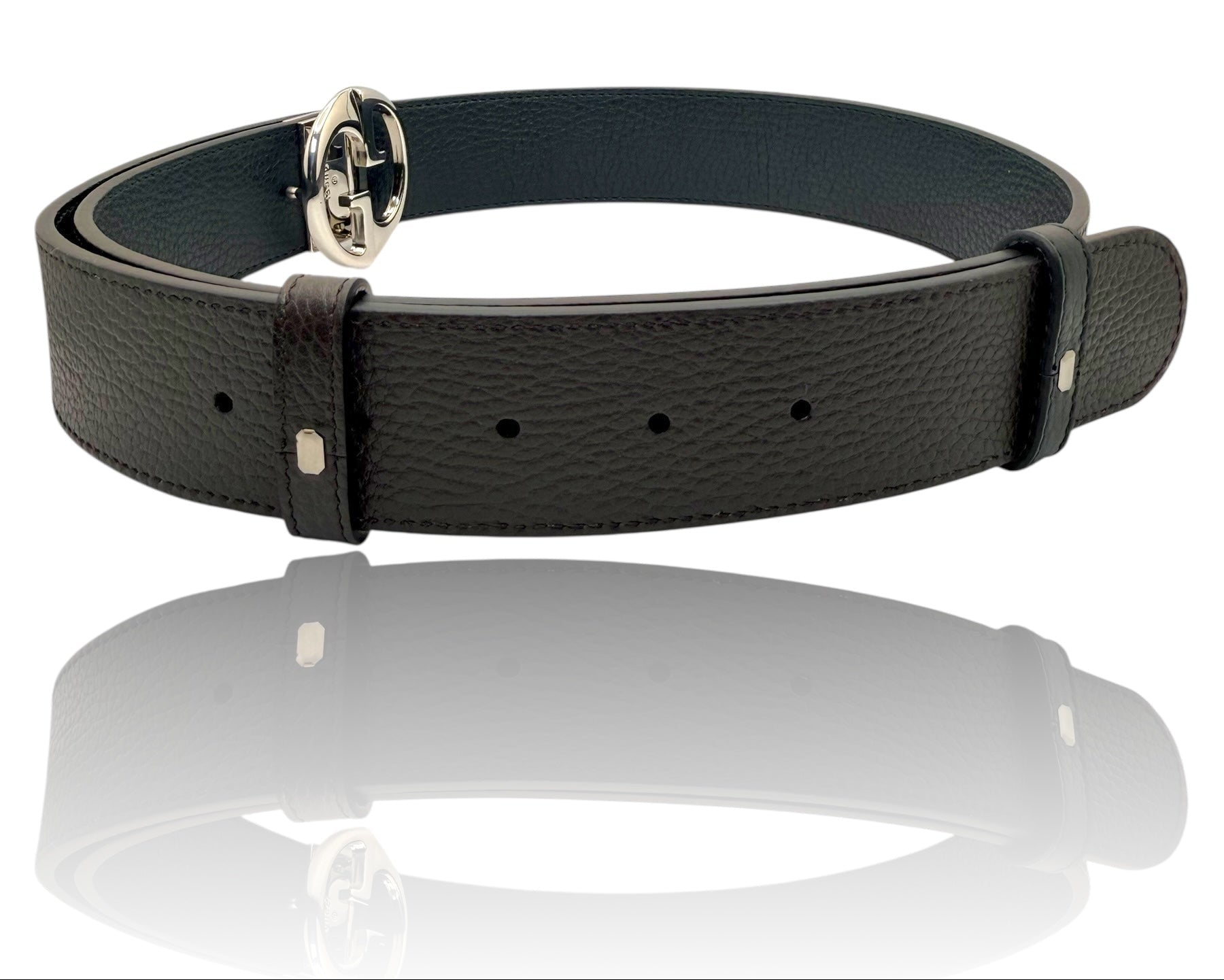 Gucci black grained leather Interlocking G belt displayed in luxury reflection shot, showcasing iconic GG buckle and premium craftsmanship.