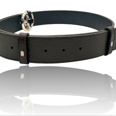 Gucci black grained leather Interlocking G belt displayed in luxury reflection shot, showcasing iconic GG buckle and premium craftsmanship.