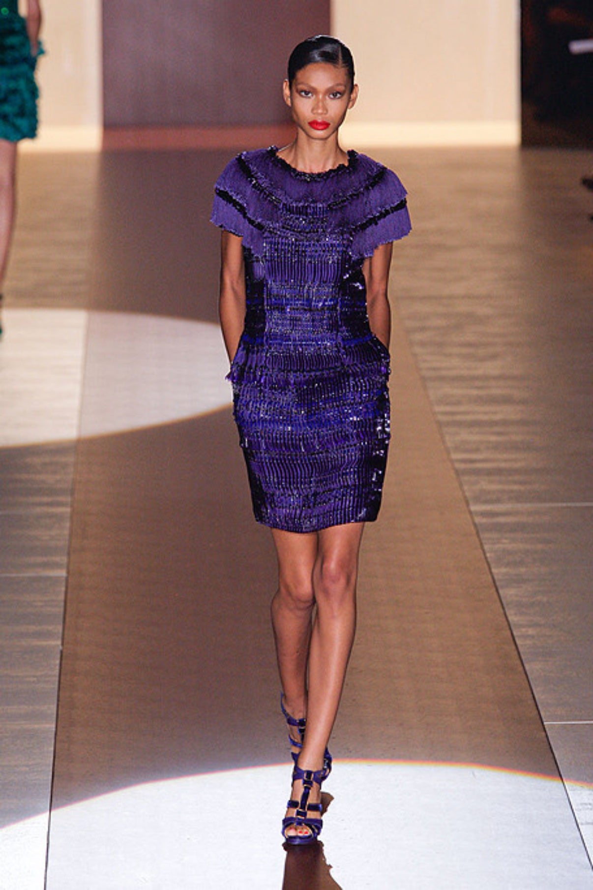 Model walking the runway wearing the original Gucci purple embellished mini dress with structured beadwork and short sleeves.