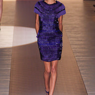 Model walking the runway wearing the original Gucci purple embellished mini dress with structured beadwork and short sleeves.