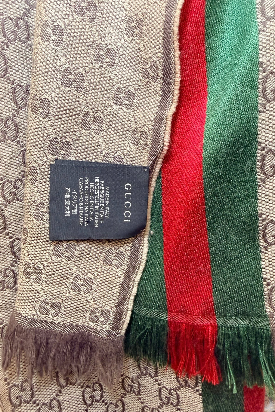 Gucci scarf authenticity label showing made in Italy tag and GG monogram fabric
