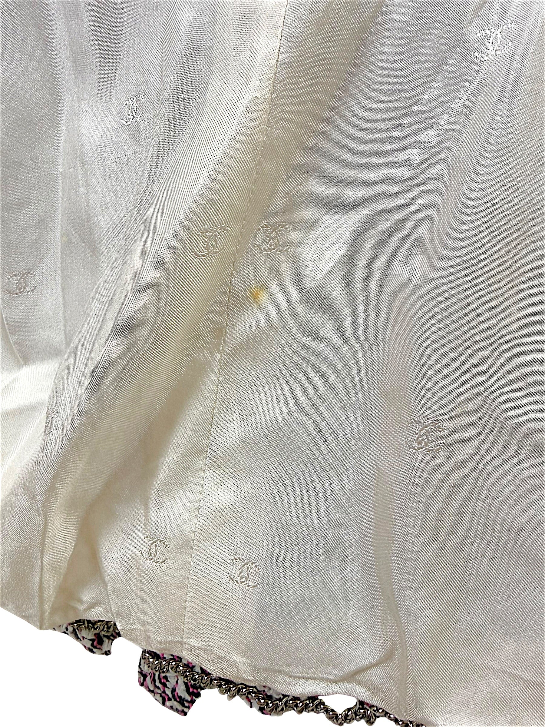 Close-up of Chanel Spring 1996 silk CC jacquard lining showing light interior spot and gold-tone chain hem detail