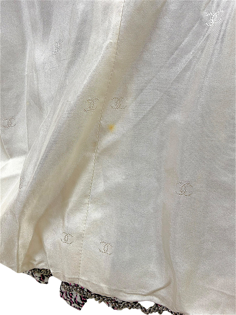 Close-up of Chanel Spring 1996 silk CC jacquard lining showing light interior spot and gold-tone chain hem detail