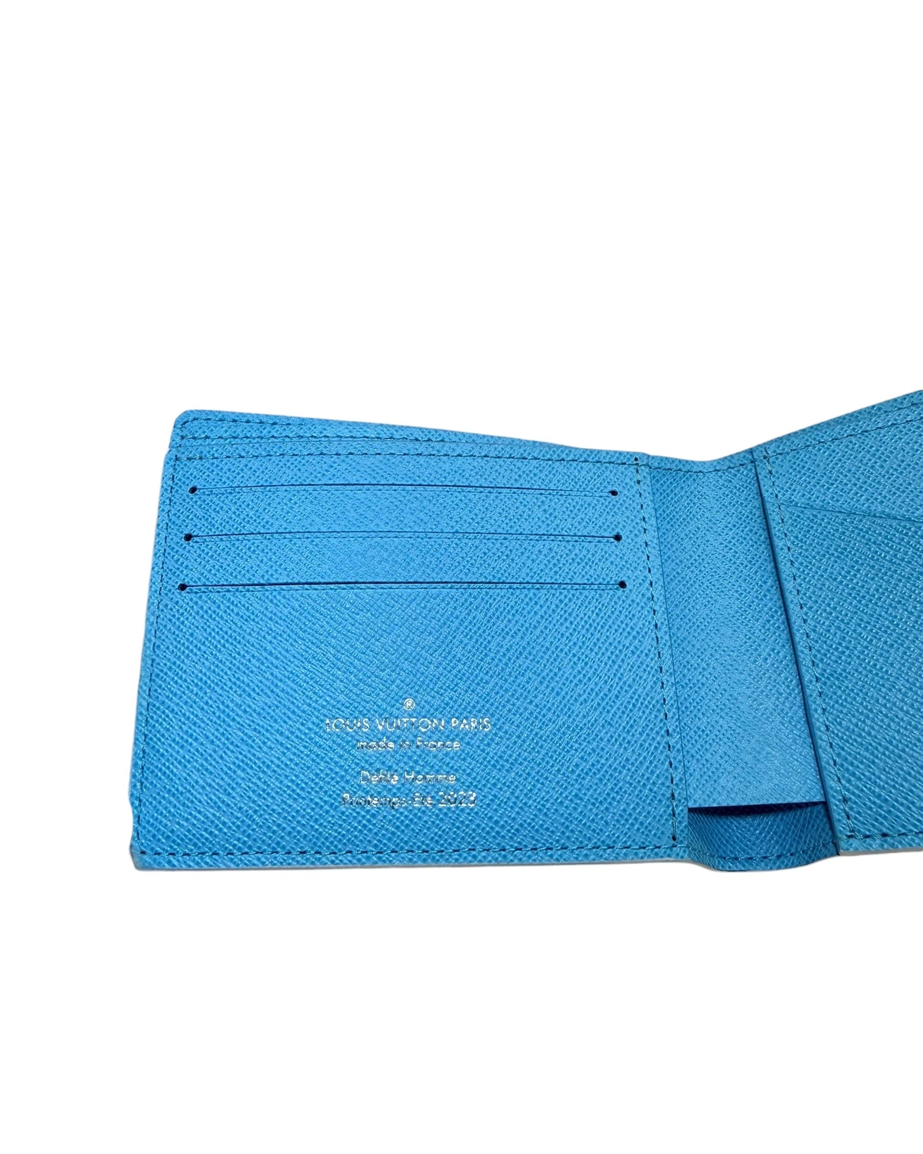 Close-up of Louis Vuitton SS23 Comics Wallet left interior card slots with blue textured leather and clean stitching.