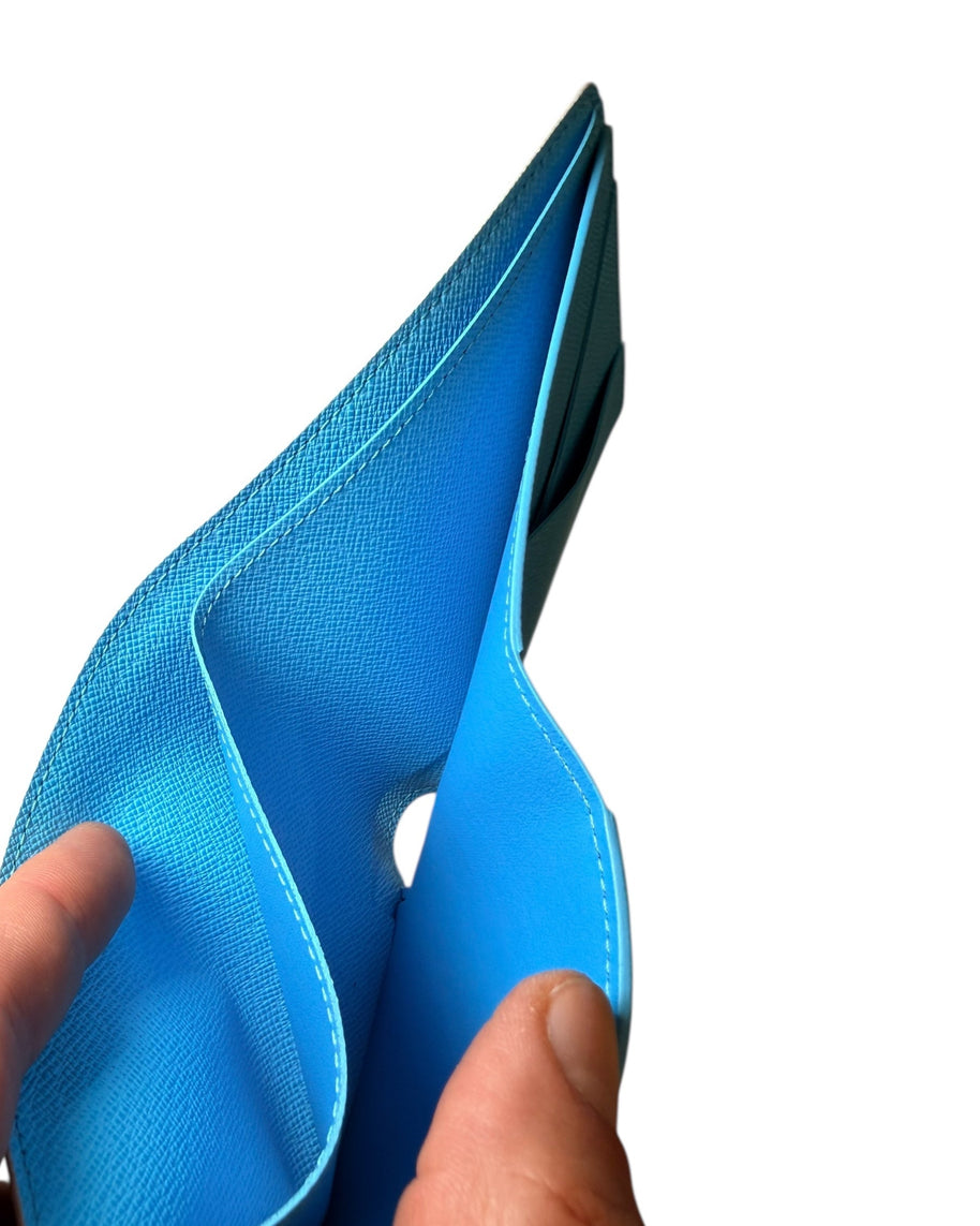 Close-up of interior compartment of Louis Vuitton SS23 Comics Wallet showing blue leather lining and stitching detail.