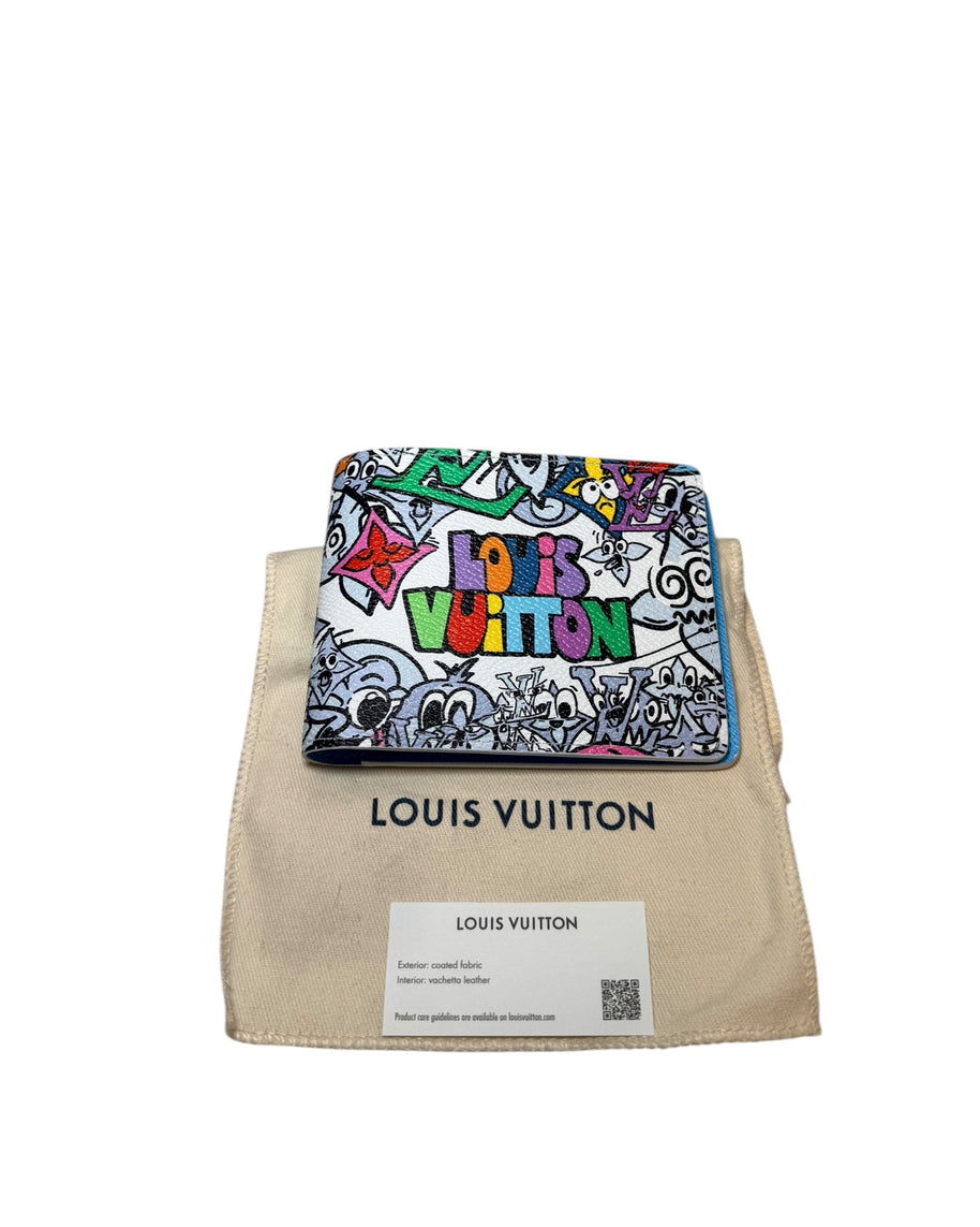 Centered front view of Louis Vuitton SS23 Comics Wallet resting on dust bag with multicolor graphic artwork.