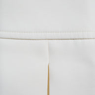 Detailed close-up of the Louis Vuitton white mini skirt showing the structured pleat and midweight fabric texture.