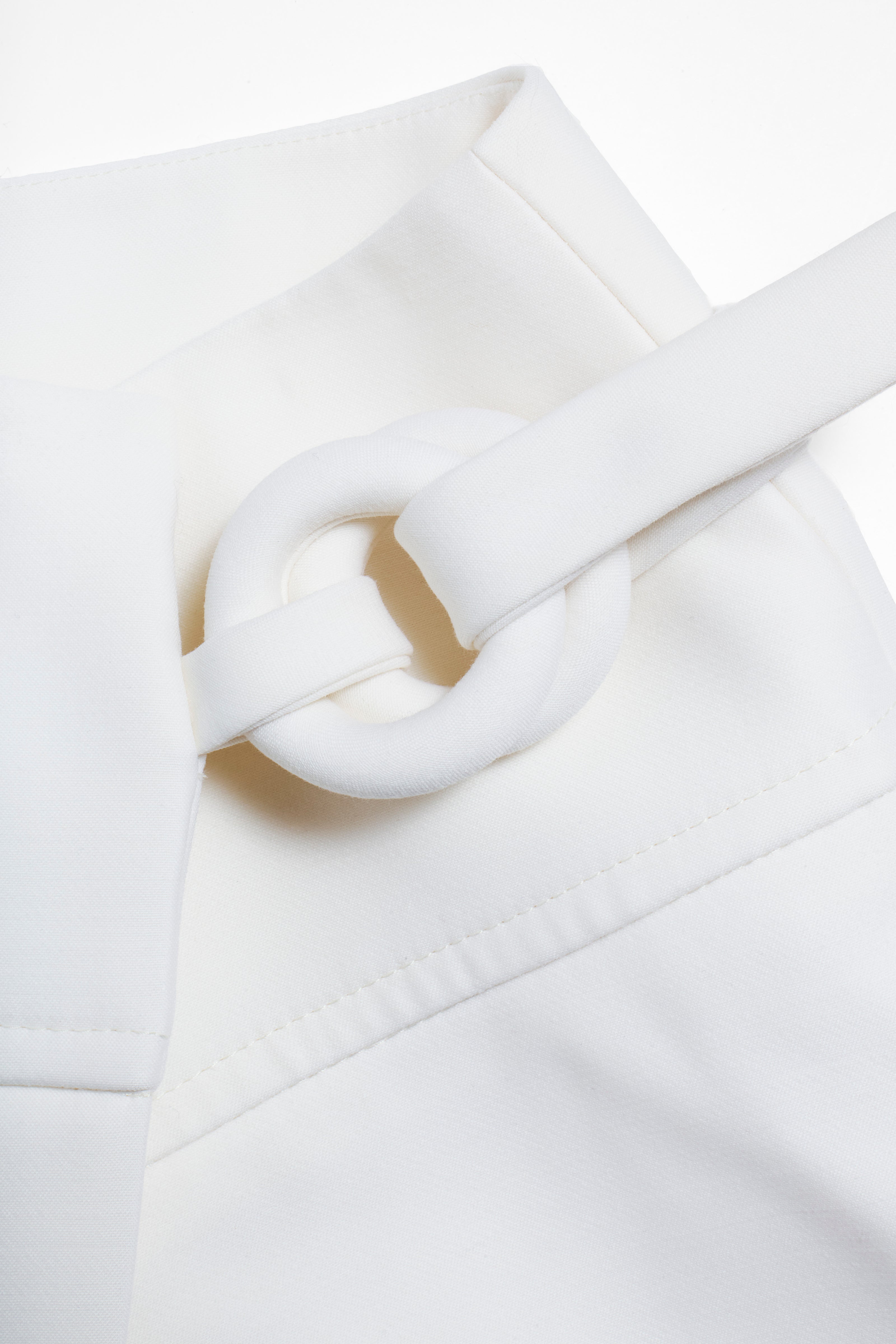 Close-up of the Louis Vuitton white mini skirt’s sculptural fabric-covered ring fastening from the Spring/Summer 2019 collection.