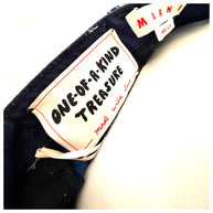 Close-up of a Marni denim fabric with a 'One-of-a-Kind Treasure' label and a visible Marni brand tag.