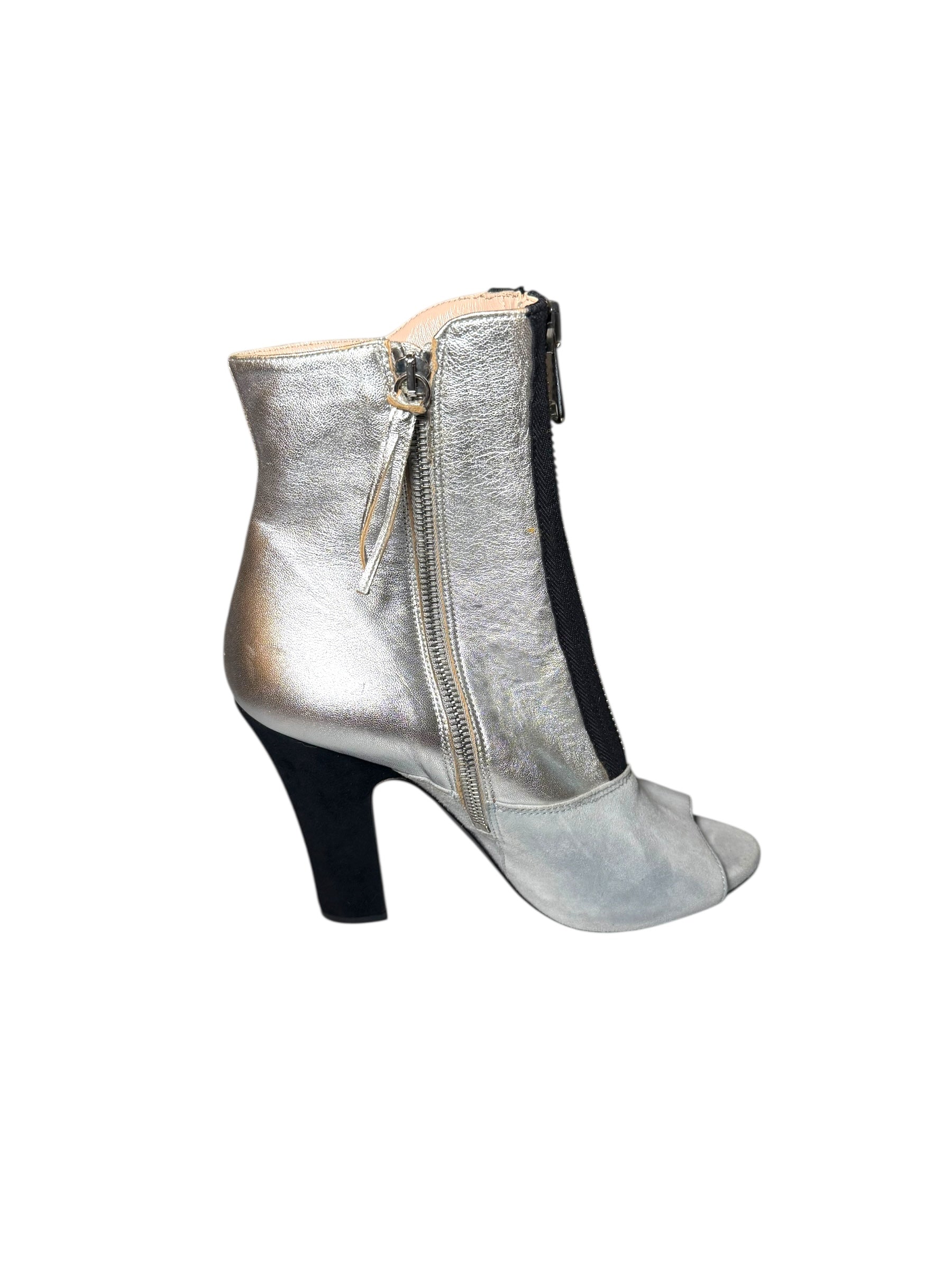 Silver Miu Miu high-heeled bootie left shoe facing right to show inner outside view of the shoe with a zipper on a white background