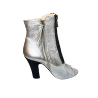 Silver Miu Miu high-heeled bootie left shoe facing right to show inner outside view of the shoe with a zipper on a white background