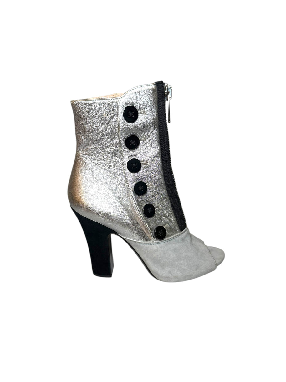 Miu Miu Silver ankle boot showing right outside bootie with black buttons and a high heel on a white background