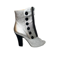 Miu Miu Silver ankle boot showing right outside bootie with black buttons and a high heel on a white background