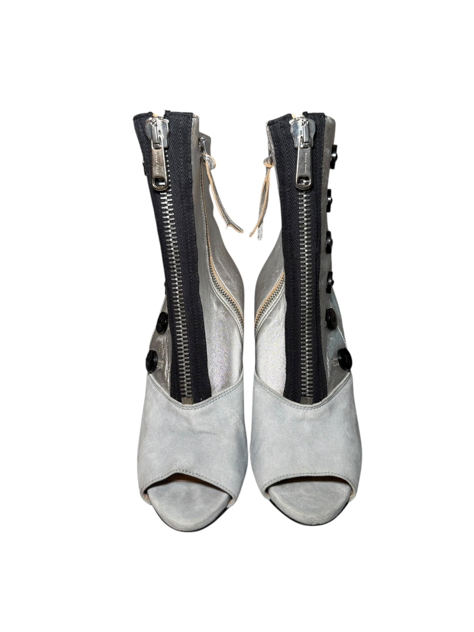 Pair of Miu Miu gray and silver peep-toe booties with zippers on a white background