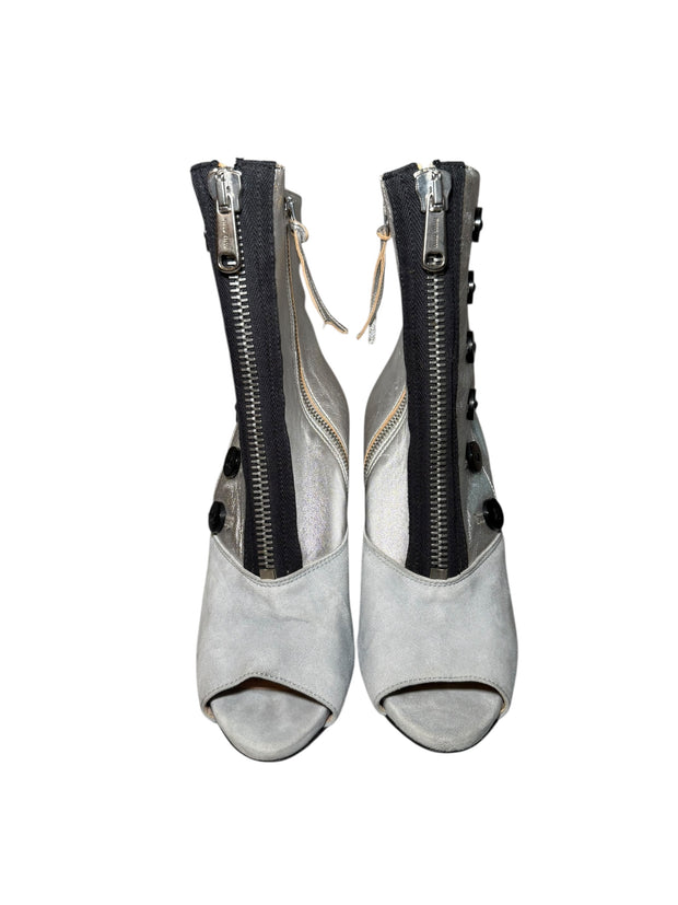 Pair of Miu Miu gray and silver peep-toe booties with zippers on a white background