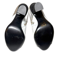 Pair of Silver Miu Miu Ankle Booties with black soles ith a visible Miu Miu brand logo on a white background