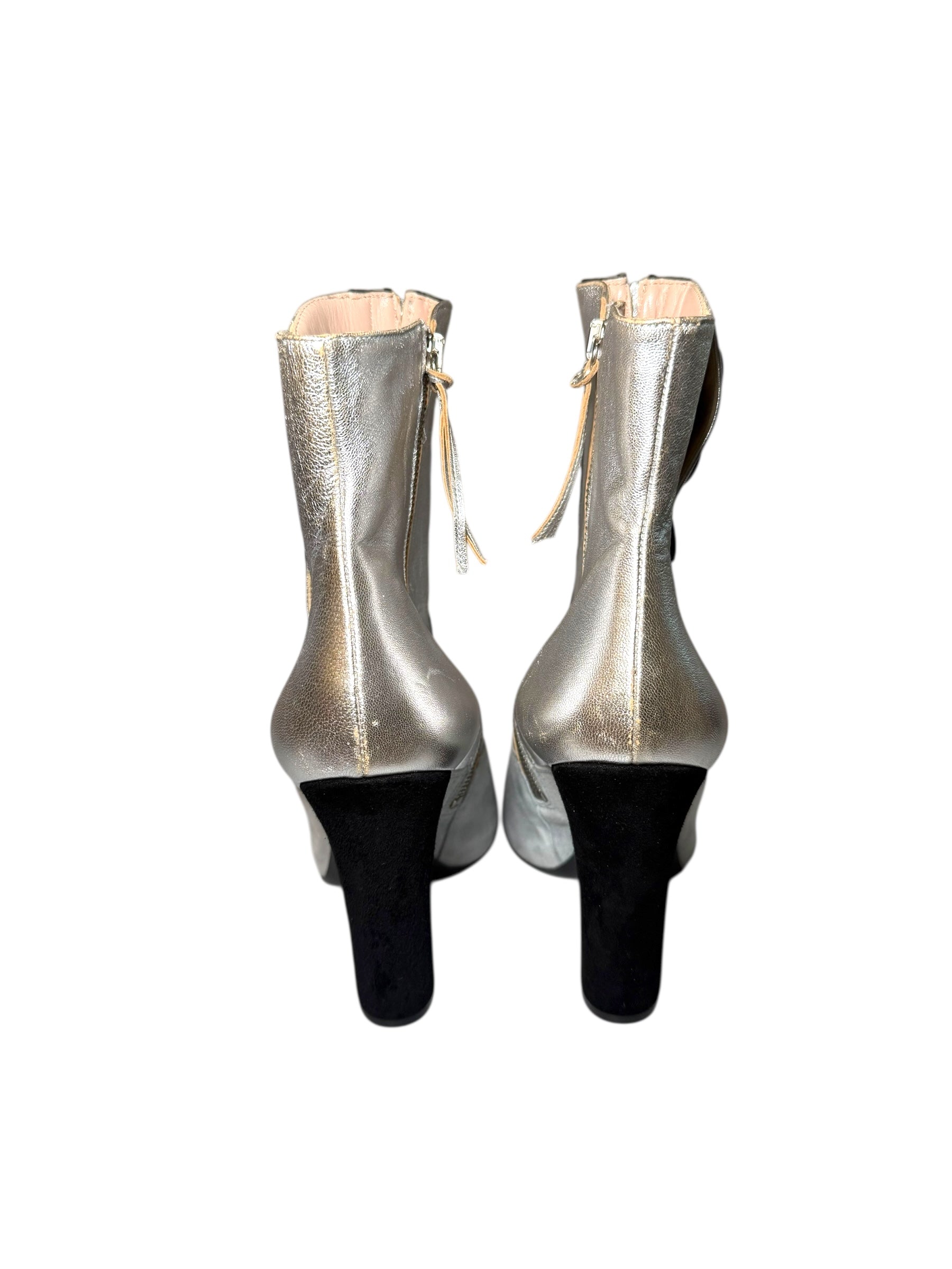 Silver Pair of Miu Miu high-heeled boots showing rear view of shoes on a white background