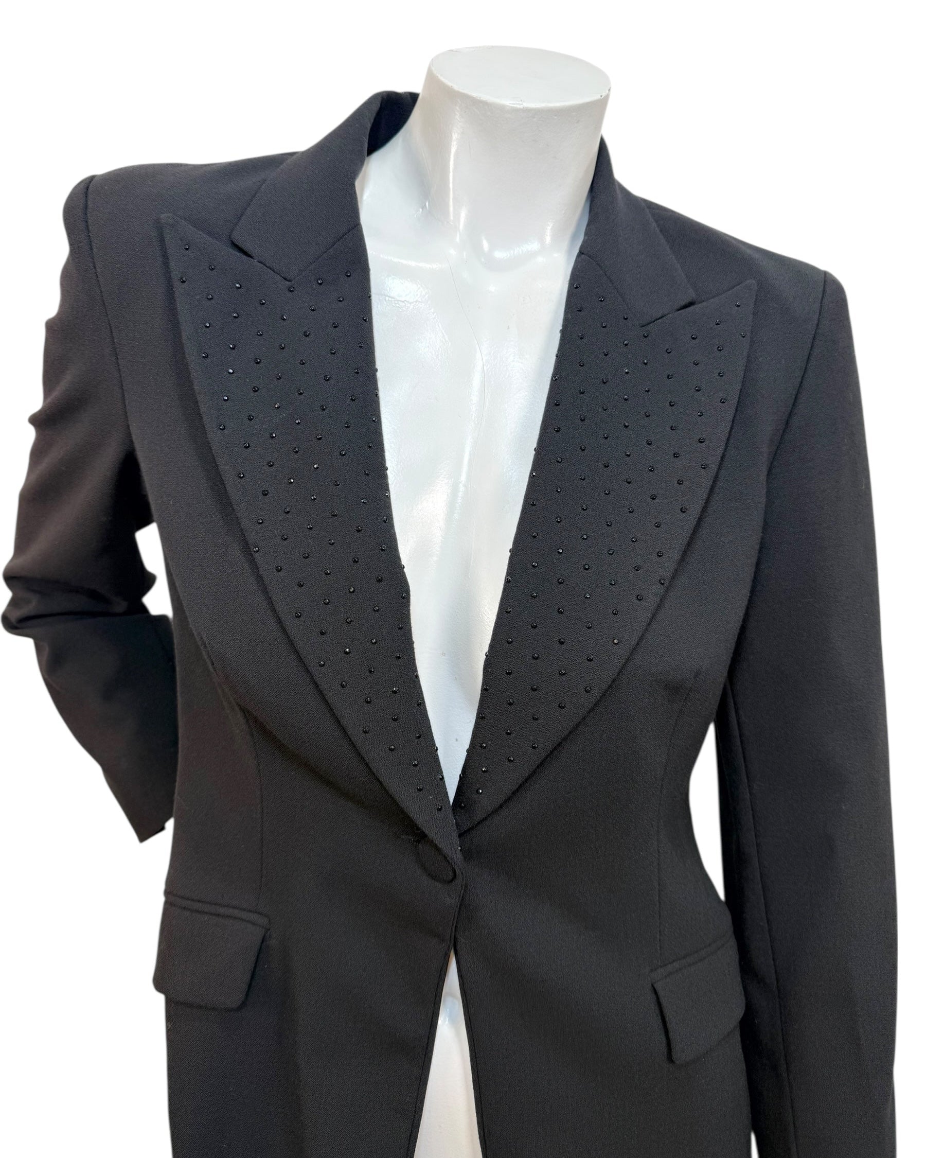 Close-up of Moschino Jeans blazer showing peaked lapels with micro stud embellishments on black wool-blend fabric