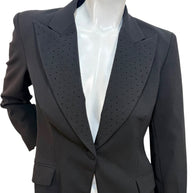 Close-up of Moschino Jeans blazer showing peaked lapels with micro stud embellishments on black wool-blend fabric
