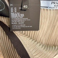 Close-up of Prada size and care label showing IT 40, Made in Italy, and pleated metallic fabric interior.