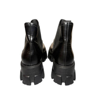 Pair of black Prada leather platform boots on a white background