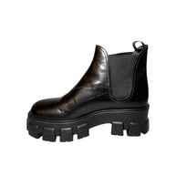 Black Prada leather boot with thick sole right shoe inner side view on a white background