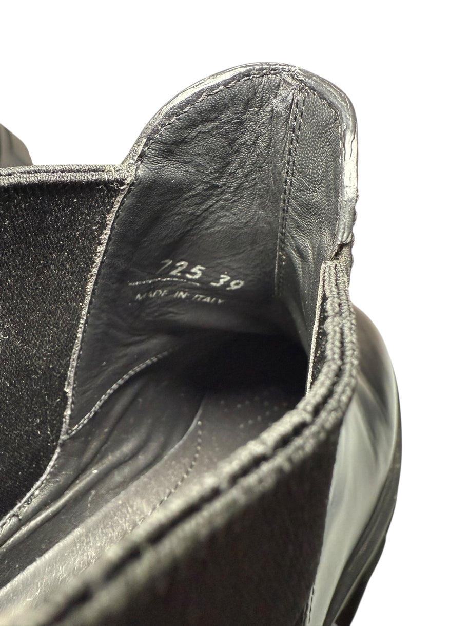 Close-up of a Prada black shoe with visible size marked '39' and stitching detail on a white background