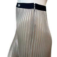 Close-up of Prada metallic pleated skirt showing elastic Prada Milano logo waistband and concealed zipper detail.