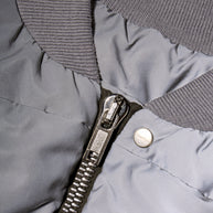 Rick Owens Bomber Jacket Close-up of zipper closure, ribbed neckline, and logo engraved snap button