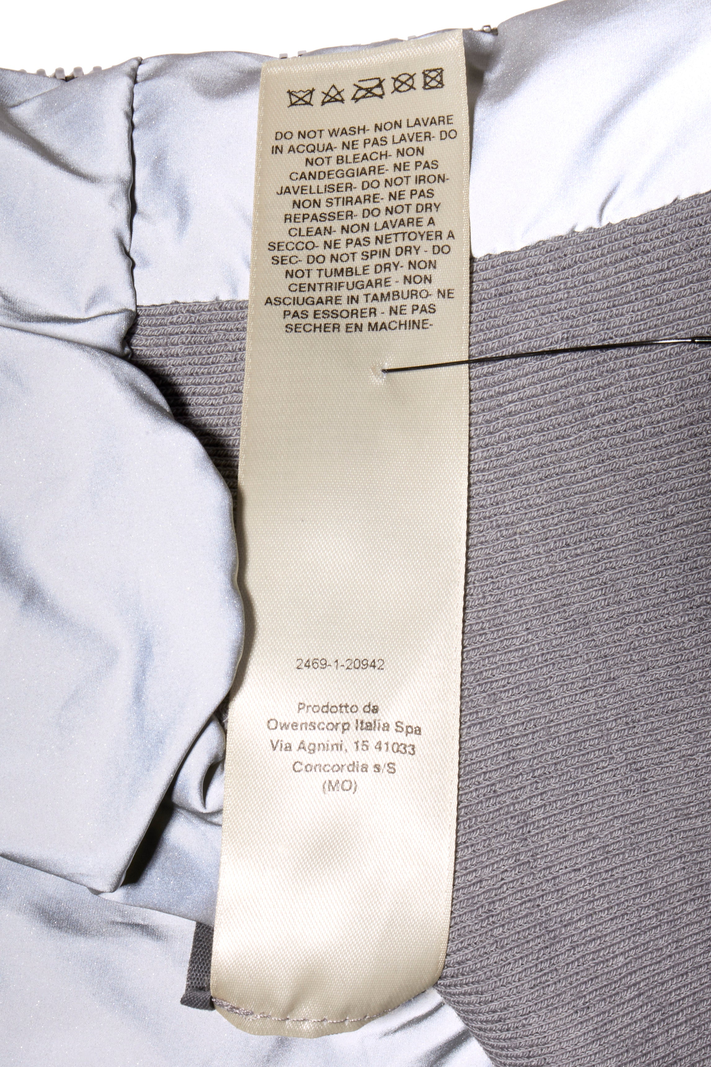 Close-up of Rick Owens Strobe Collection Bomber Jacket wash tag label on metallic and dark gray fabrics