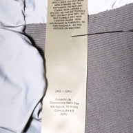 Close-up of Rick Owens Strobe Collection Bomber Jacket wash tag label on metallic and dark gray fabrics