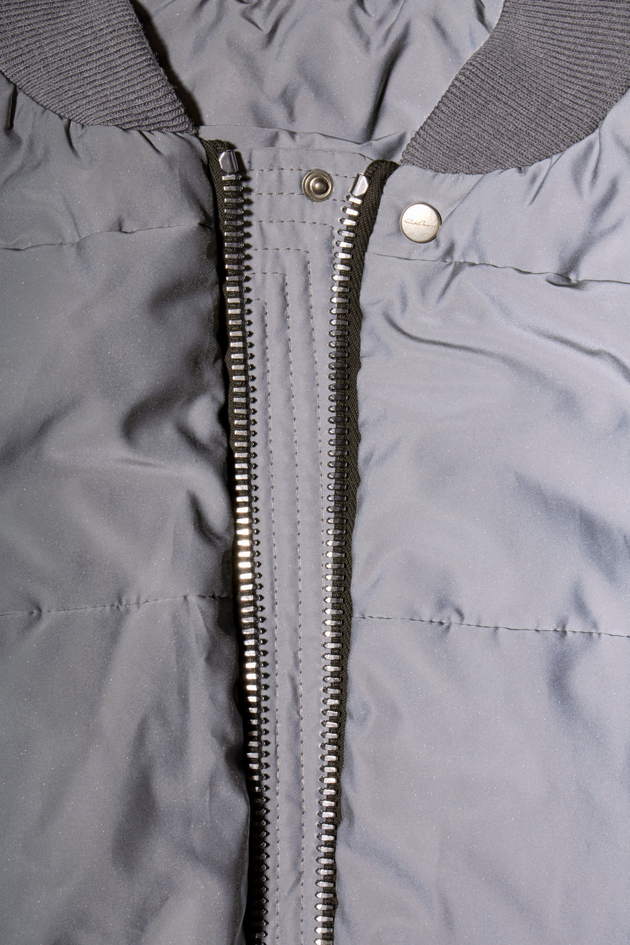 Close-up of Rick Owens Strobe collection gray bomber jacket with a zipper and Rick Owens label on snap button