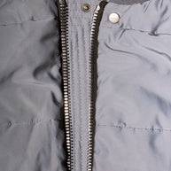 Close-up of Rick Owens Strobe collection gray bomber jacket with a zipper and Rick Owens label on snap button