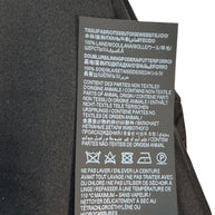 Fabric composition and care label of Saint Laurent Paris black wool jumpsuit with silk lining and cleaning instructions.